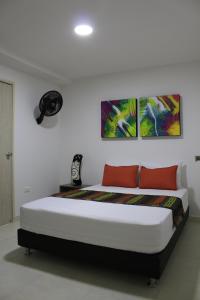 佩雷拉Hotel Pereira 421的卧室配有一张墙上三幅画作的床