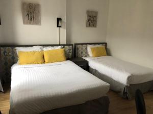 鲁昂雷伊尼蒂耶酒店的两张带黄色枕头的床