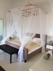 贝鲁沃勒伊莎贝拉酒店的一间卧室配有带蚊帐的天蓬床。