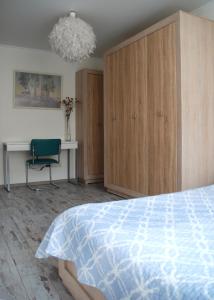 切尔尼戈夫Бело-голубая безмятежность的一间卧室配有一张床、一把椅子和一个吊灯。