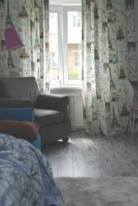 切尔尼戈夫Бело-голубая безмятежность的带沙发和窗户的客厅