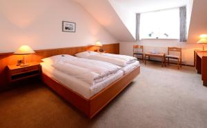 Jübek古斯酒店的酒店客房设有一张大床和一张桌子。