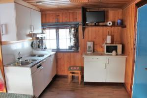 StölletVärnäs Camping的厨房配有白色橱柜、水槽和微波炉