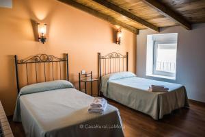 AstudilloCasa Rural "La Mota"的一间卧室设有两张床和窗户。