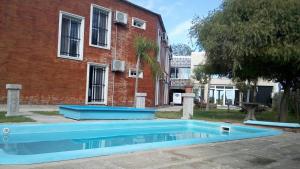 Maciel生活酒店的砖砌建筑前的蓝色游泳池