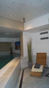 韦斯特兰塞尔特尔霍夫酒店的游泳池,位于游泳池旁的一座带椅子的建筑内