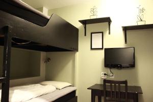 乌普萨拉乌普萨拉中央车站青年旅舍的一间卧室配有一张双层床、一台电视和一张书桌