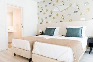 纳扎雷魔术酒店的卧室内的两张床,卧室的墙上有蝴蝶