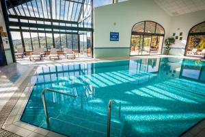 圣洛朗－德塞尔当法尔格地区高尔夫及spa酒店的大楼内的一个蓝色海水游泳池