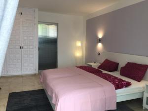 La Victoria de AcentejoLa Palmita的卧室配有带红色枕头的大型白色床
