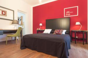 马尔萨拉Il Sogno Apartments的一间卧室设有一张床和红色的墙壁