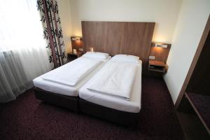 美因河畔法兰克福动物园酒店的一间位于酒店客房内的带两张床的卧室