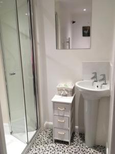 里弗姆Wood Farm Kerdiston的白色的浴室设有水槽和淋浴。