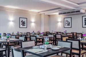 巴乌鲁蓝树塔包鲁酒店的用餐室配有桌椅和紫色鲜花