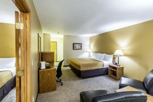 Valley CityEcono Lodge - Valley City的配有一张床和一把椅子的酒店客房