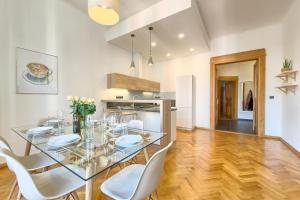 布拉格Spacious And Bright Apartment Dusni 13的一间设有玻璃桌和白色椅子的用餐室