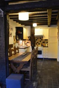 瑟穆瓦河畔夫雷斯La Petite Passerelle à Mouzaive的一个带木桌和椅子的大厨房