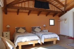 萨法德Off The Square的配有橙色墙壁和木制天花板的客房内的两张床