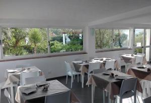 兰佩杜萨奥斯卡萨布兰卡酒店的餐厅设有白色的桌椅和窗户。