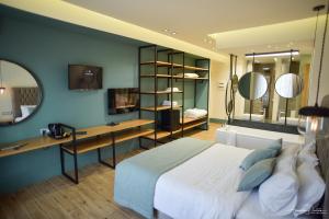 亚历山德鲁波利斯Thalassa Apart Hotel的一间卧室配有一张床、一张书桌和一面镜子