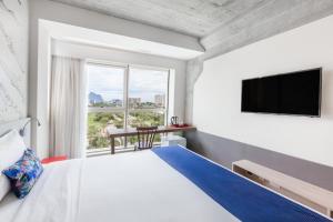 里约热内卢Ribalta Hotel Barra da Tijuca by Atlantica的一间卧室设有一张大床和一个大窗户
