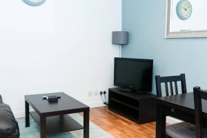伦敦1BD Apartment in Dalston的客厅配有电视和桌子