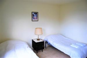 乌斯怀亚卡瓦尼亚斯德尔海恩山林小屋的一间卧室配有两张床和床头灯。