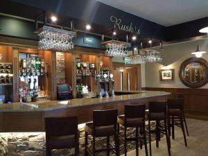 五英里镇Clogher Valley Golf Club的餐厅内的酒吧配有椅子和吊灯
