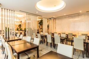 东京MYSTAYS 大森精品酒店的配有木桌和白色椅子的餐厅