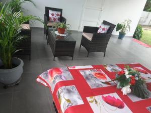 拉芒坦Villa Bananier的一间设有椅子和一张桌子及红色毯子的房间