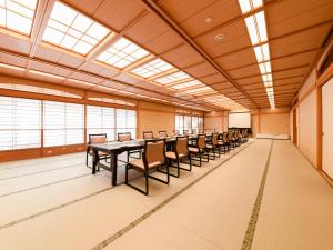 敦贺市新所皮亚敦贺酒店的大房间设有一张长桌子和椅子