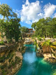 普拉亚卡门Hotel Xcaret Mexico All Parks All Fun Inclusive的主题公园的蓝色海水游泳池