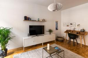 莱比锡Apartment Waldstraßenviertel的客厅配有大电视和书桌