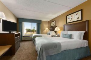费耶特维尔Wingate by Wyndham, Fayetteville NC的酒店客房设有两张床和电视。