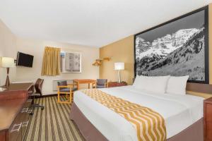 拉夫兰拉夫兰/柯林斯堡地区客之家酒店的酒店客房设有一张大床和一张书桌。