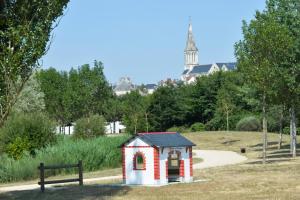 Le Louroux-BéconnaisLogis de l'Hermitage的公园里的一个红色和白色的小狗屋
