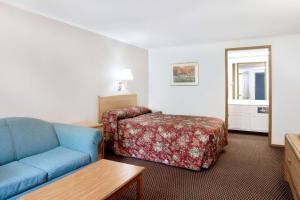 皮茨顿Knights Inn Pittston的酒店客房,配有床和蓝色的沙发