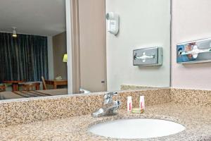 阿普兰阿普兰速8酒店的一间带水槽和大镜子的浴室