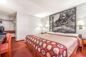 北卑尔根速8北卑尔根酒店的酒店客房设有一张壁挂着大画的床铺。