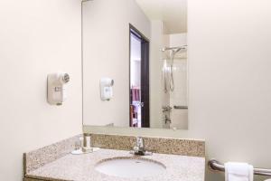 惠灵Super 8 by Wyndham Wheeling Saint Clairsville OH Area的一间带水槽和镜子的浴室