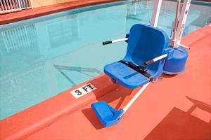 劳德代尔堡劳德代尔堡旅行酒店的游泳池旁的蓝色椅子