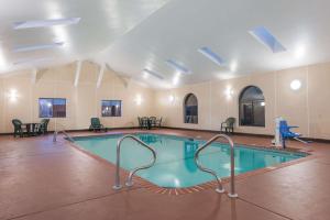 圣查尔斯圣查尔斯速8酒店的一个带桌椅的大房间中的游泳池