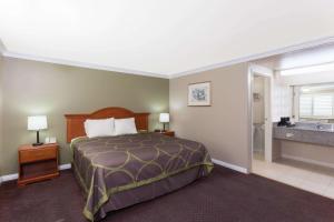 托伦斯速8托兰斯LAX机场区酒店的一间酒店客房 - 带一张床和一间浴室