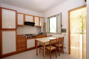维耶斯泰Residence Delfino的厨房配有桌椅和窗户。