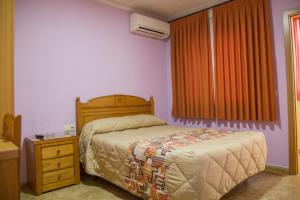 托梅略索桑丘旅馆的一间卧室配有一张床、一个梳妆台和一扇窗户。