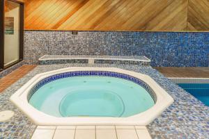 坎贝尔顿速8坎贝尔顿酒店的浴室设有蓝色瓷砖,配有按摩浴缸。