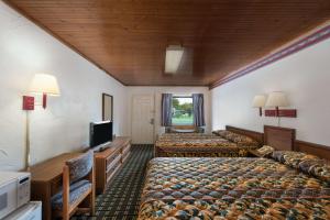 布朗伍德Post Oak Inn的酒店客房设有两张床和一台平面电视。