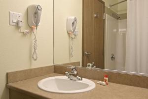圣热罗姆速8圣-杰罗姆酒店的一间带水槽的浴室和墙上的一部电话