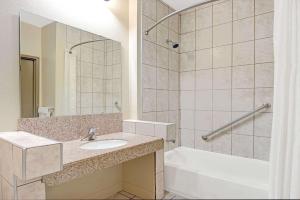 伍德森特瑞斯圣路易斯机场速8酒店的一间带水槽、浴缸和淋浴的浴室