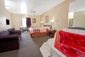 伍德森特瑞斯圣路易斯机场速8酒店的酒店客房设有床和客厅。